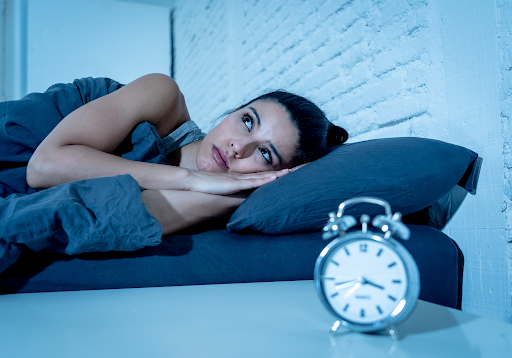 Woman lying awake looking at clock